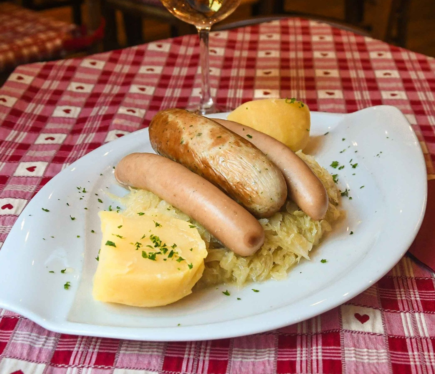 Choucroute servie en assiette : saucisse blanche, saucisse fumée, pomme de terre, chou compotté