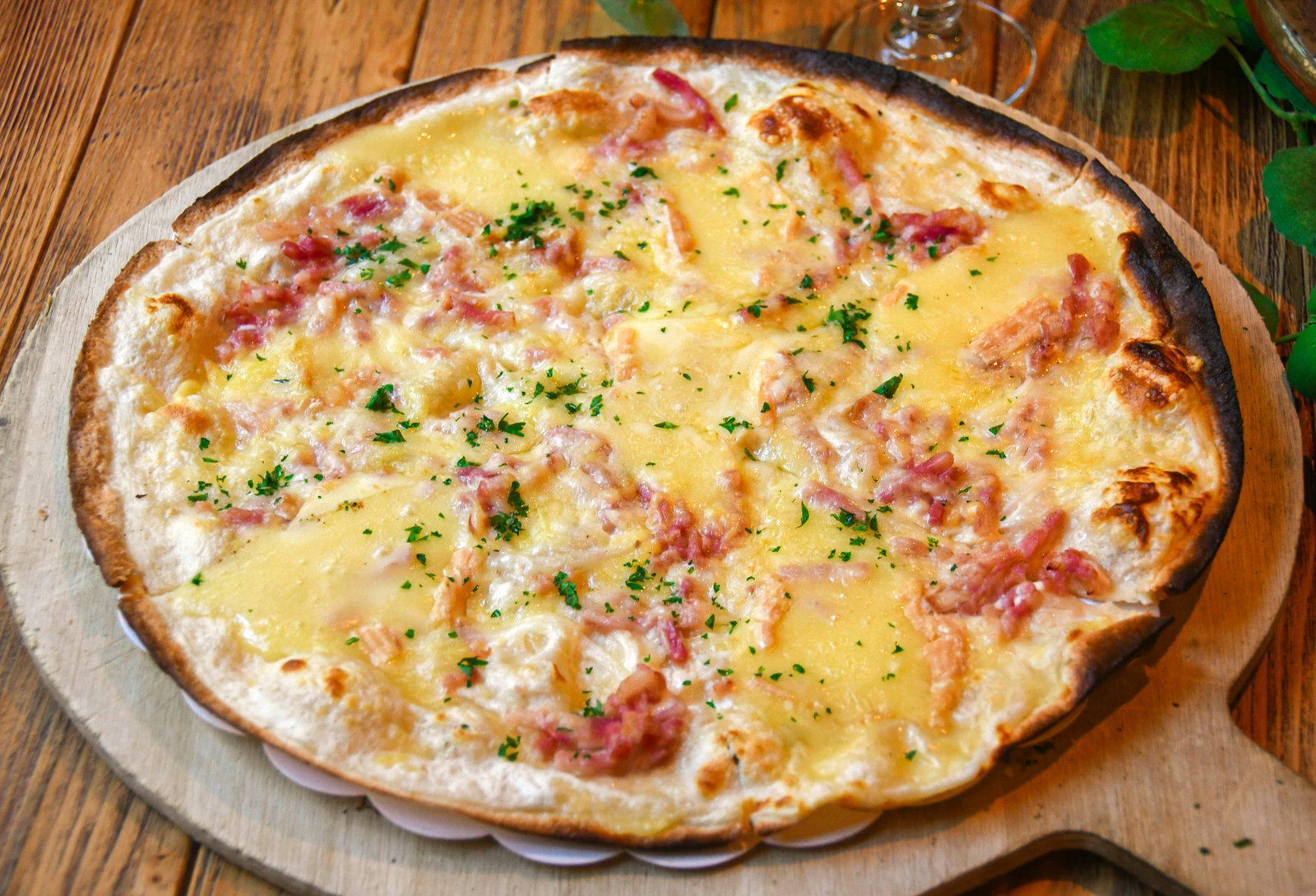 Tarte flambée alsacienne, sortie du four, sur planche de bois