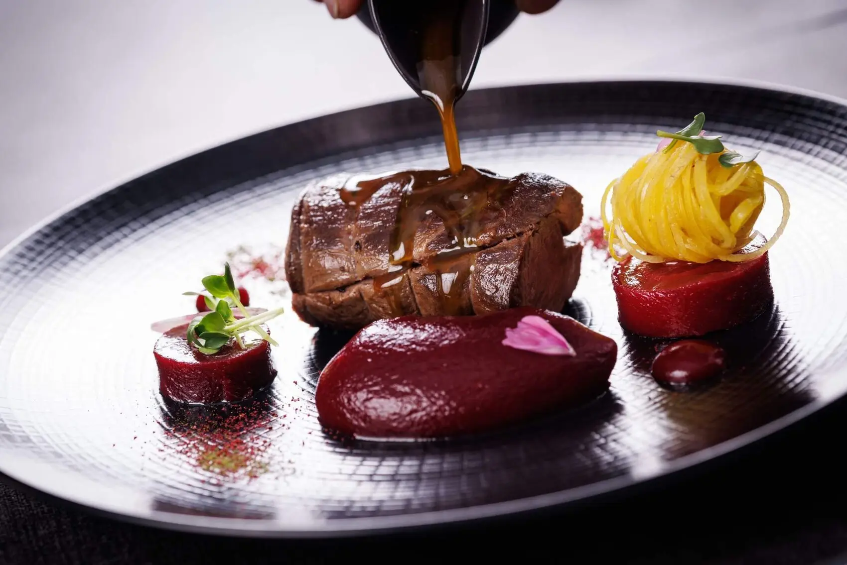 Plat signature du restaurant, sauce versée à l'assiette